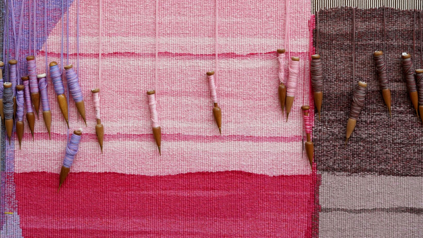 A detail of a brightly coloured tapestry with geometric shapes on the loom at the Australian Tapestry Workshop.