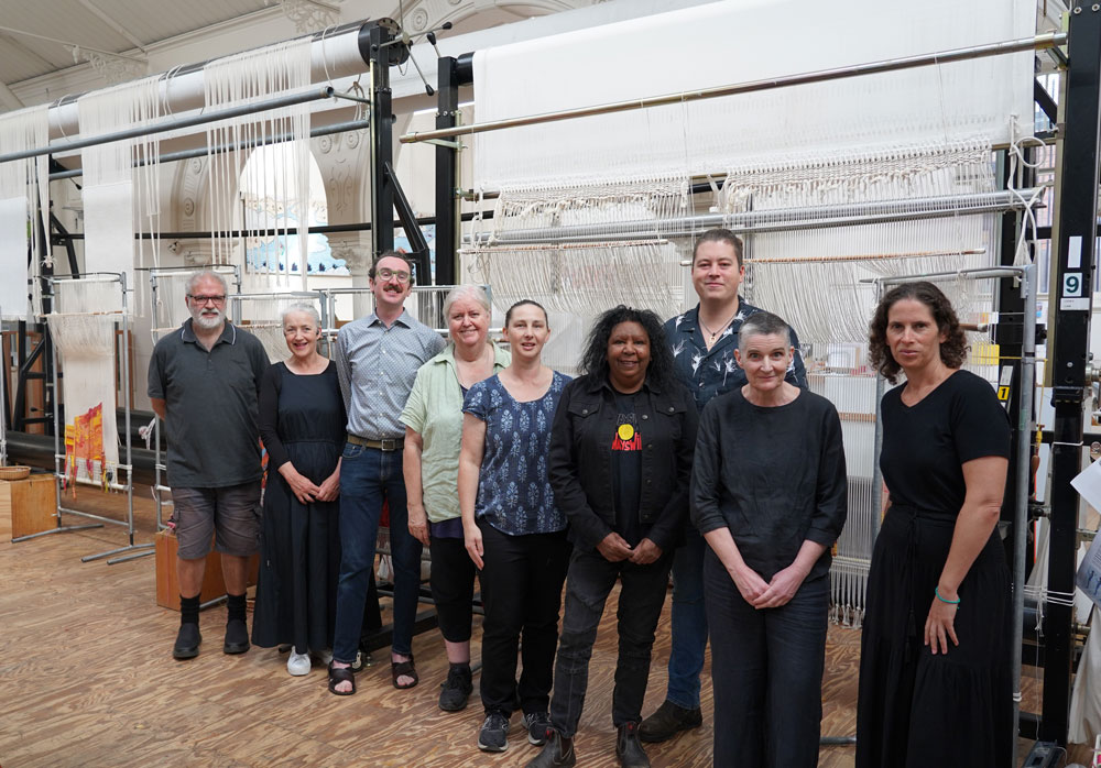 Maree Clarke (Yorta Yorta/Wamba Wamba/Mutti Mutti/Boonwurrung) and Mitch Mahoney (Boonwurrung/Barkindji) with ATW Weavers at the Australian Tapestry Workshop. 