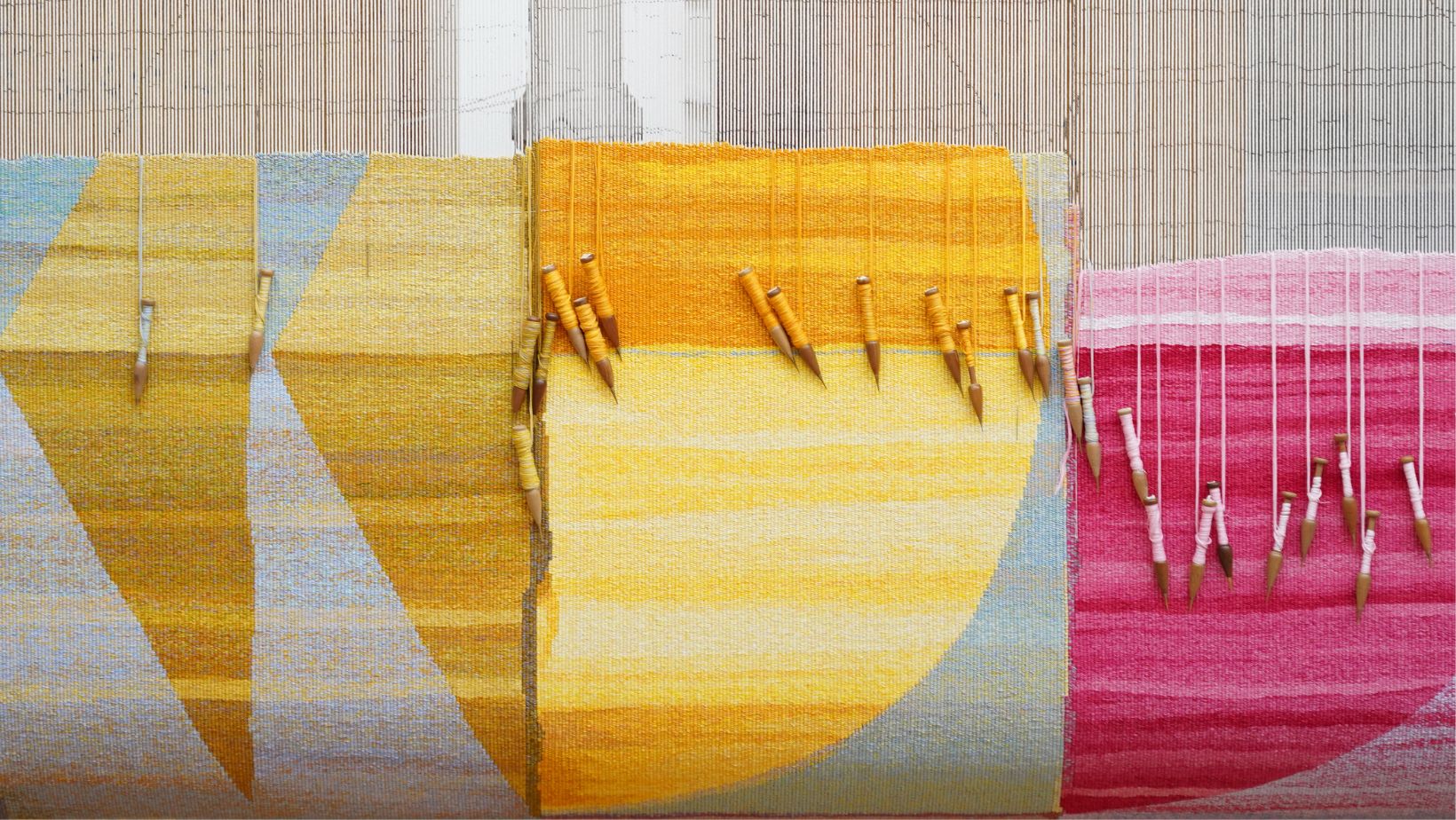 A brightly coloured tapestry with Geometric shapes on the loom at the Australian Tapestry Workshop.