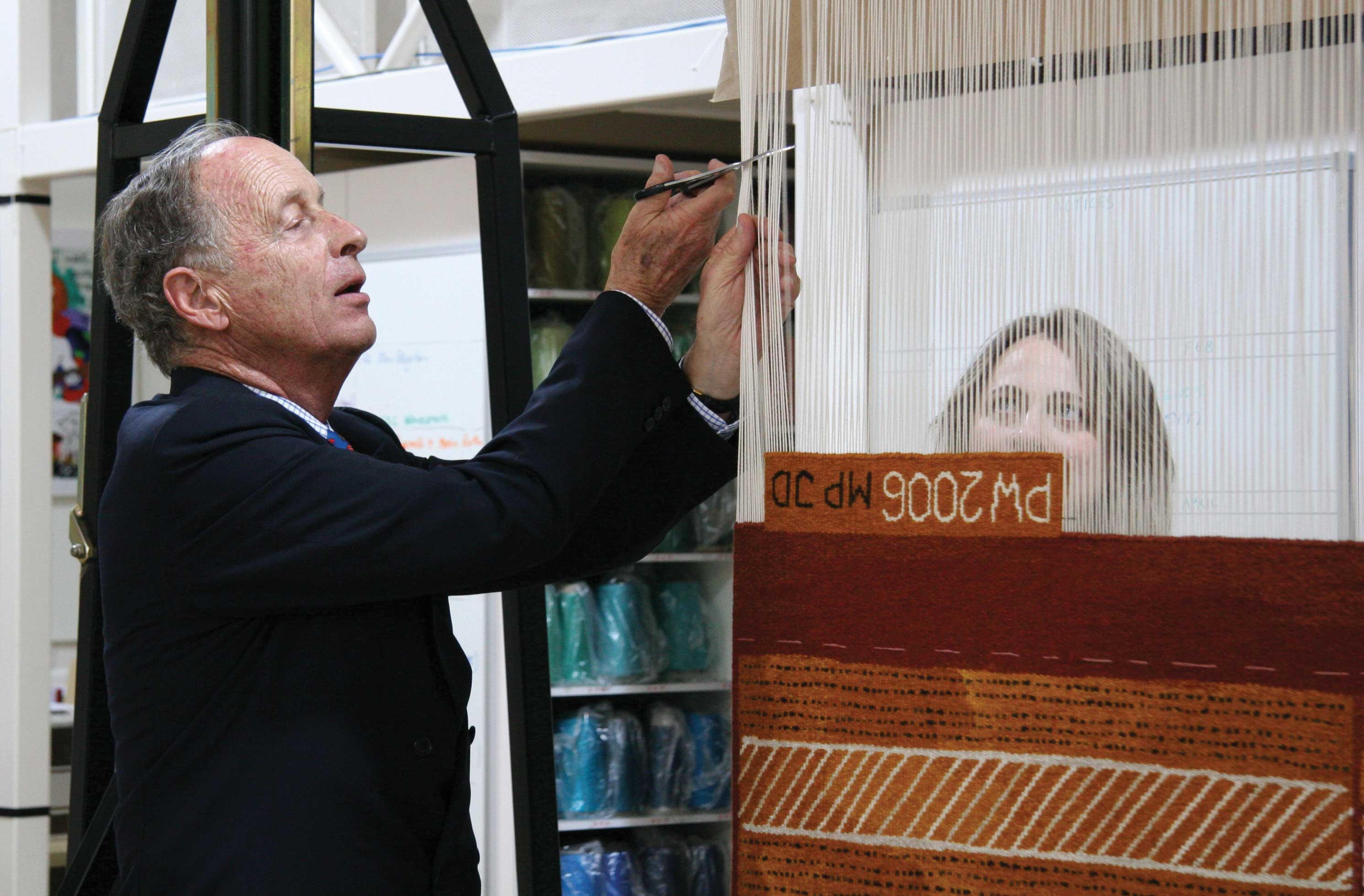 Cutting Off Ceremony: Baillieu Myer AC cutting off ‘Pwoja Pukumani body paint design’ 2005, Pedro Wonaeamirri, handwoven by Milena Paplinska and John Dicks, wool, cotton, 1.2 x 2.3m. Photograph: Viki Petherbridge.