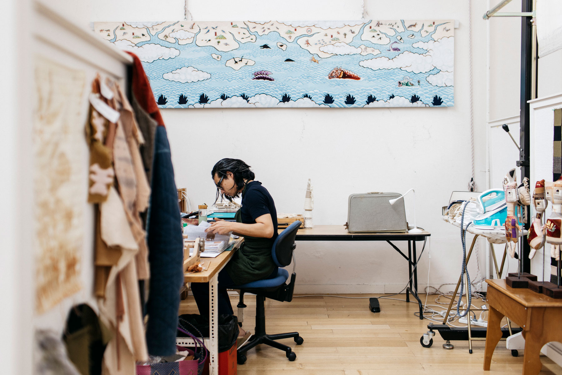 Phong Chi Lai in the ATW Residency Studio, Photo by Marie-Luise Skibbe. Phong Chi Lai working in a studio filled with textiles