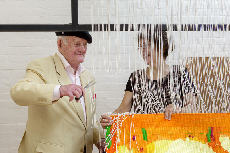 Cutting Off Ceremony for ‘Sun over the You Beaut Country,’ 2014, designed by John Olsen AO OBE, woven by Sue Batten, Chris Cochius, Pamela Joyce, Milena Paplinska & Cheryl Thornton. Photograph: Jeremy Weihrauch.