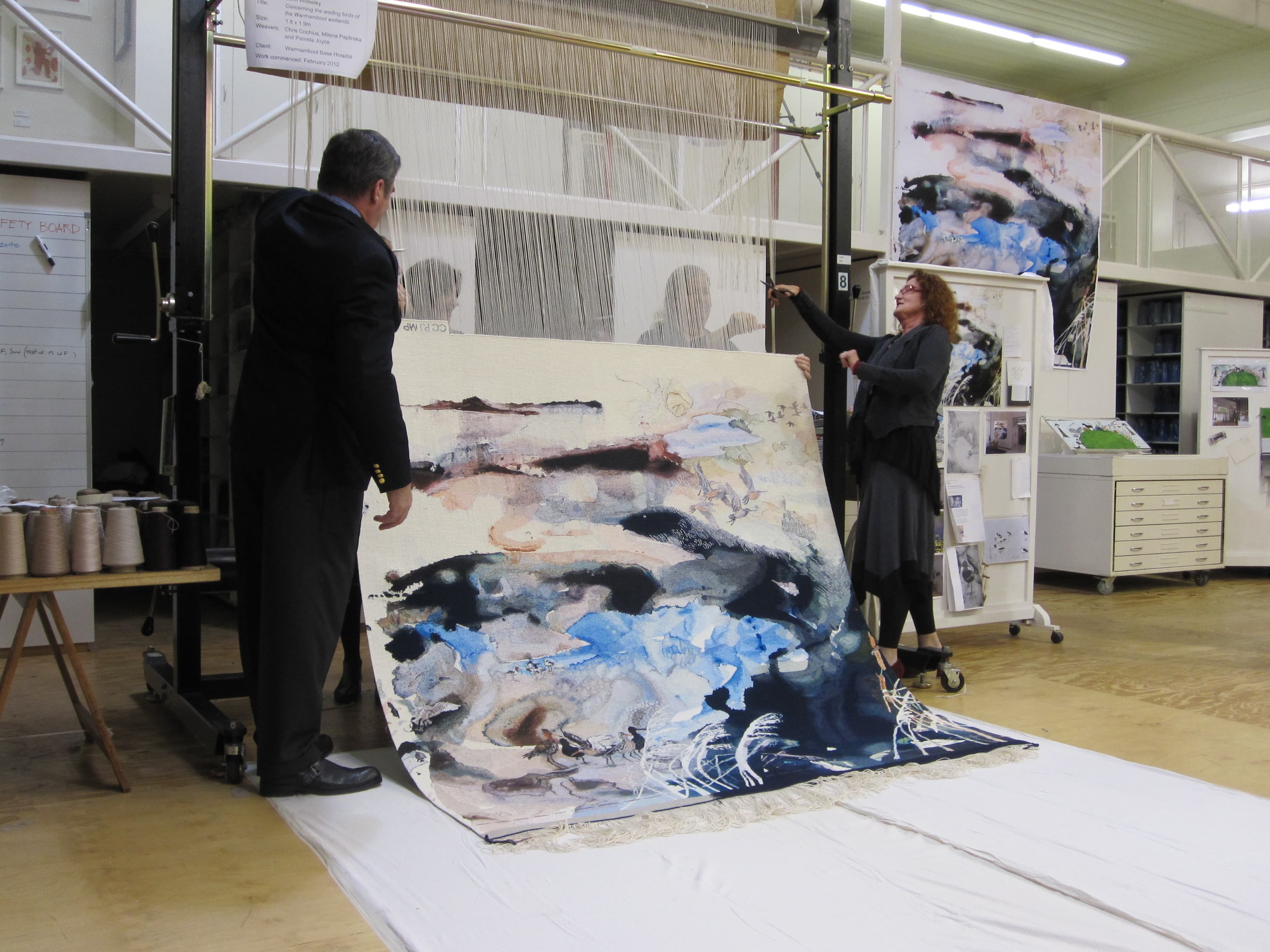 Cutting Off Ceremony for ‘Concerning the wading birds of the Warrnambool wetlands’ 2012, designed by John Wolseley, woven by Chris Cochius, Pamela Joyce & Milena Paplinska, wool and cotton, 1.80 x 1.90m. Photograph: ATW.